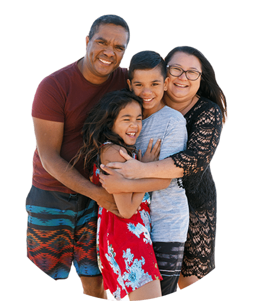 Aboriginal family of 4, hugging and smiling on beach
