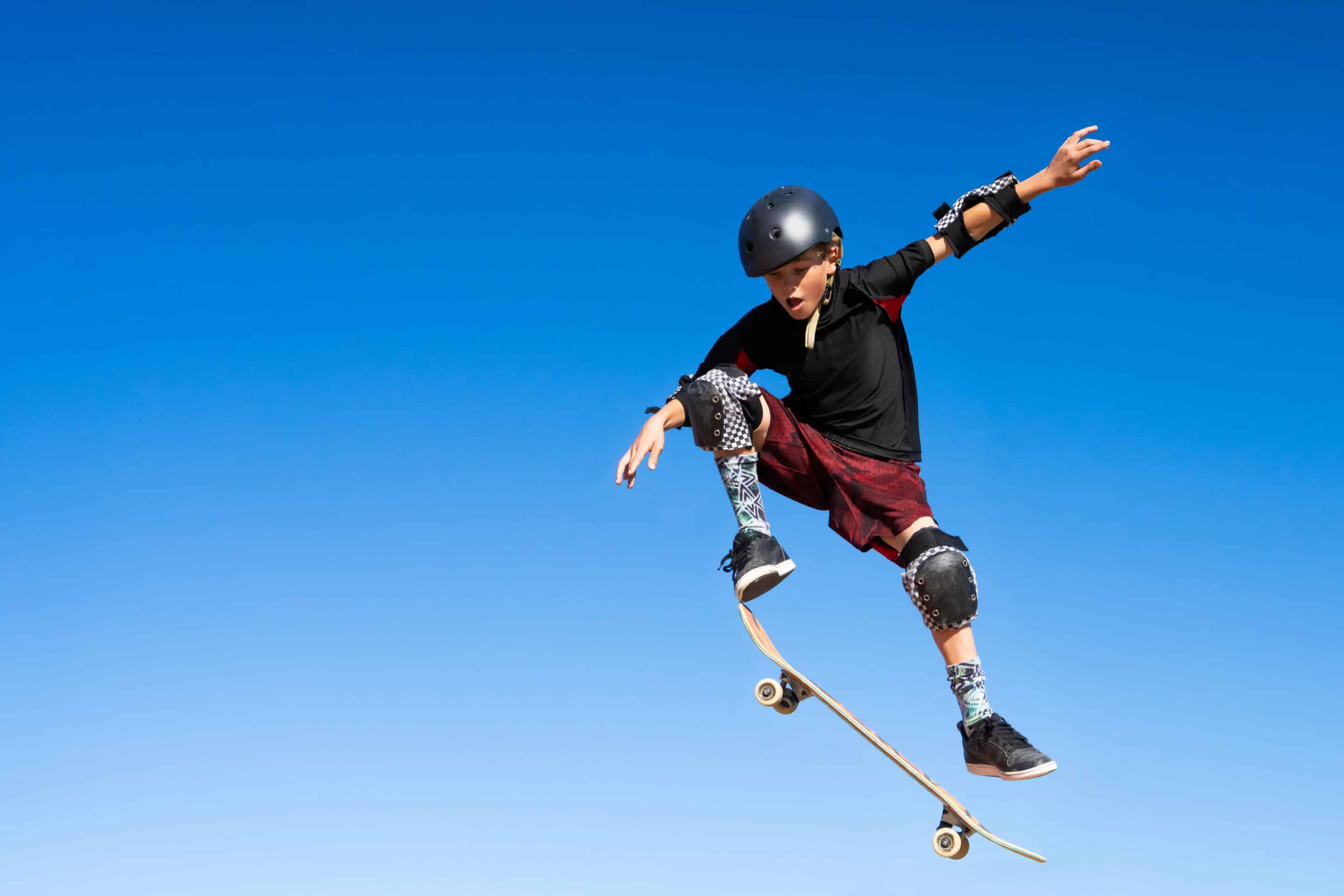 Young Boy On A Skateboard Jumping Into The Air
