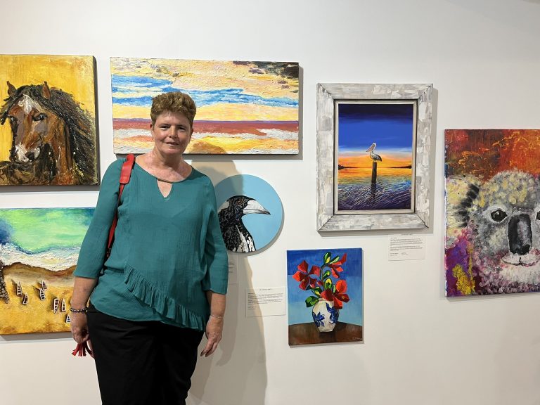 Art Without Limits artist Julie Raju in front of her landscape artwork