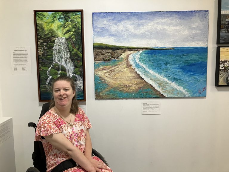 Art Without Limits artist Katie Rogers in front of her landscape artwork