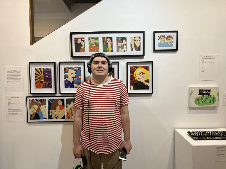 Art Without Limits artist Riley Treloar in front of his art collection