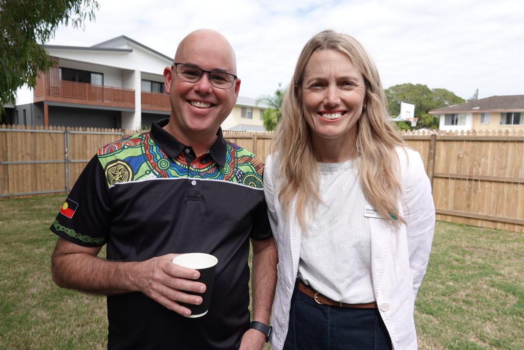 Smiling bald man and blonde woman in a white jacket at headspace Ballina opening 