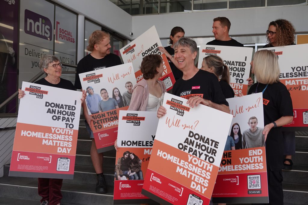 Social Futures staff hold signs promoting Youth Homelessness Matters Day