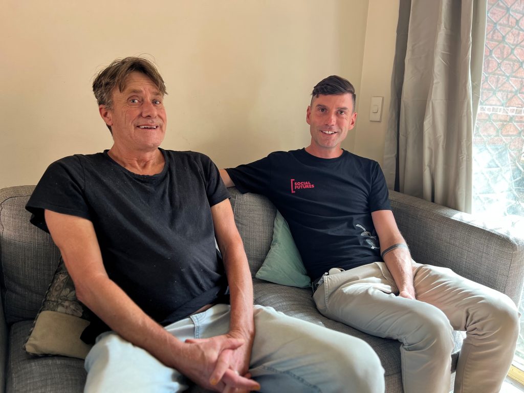 Two men, Stephan and Christian, sit next to each other on a couch 