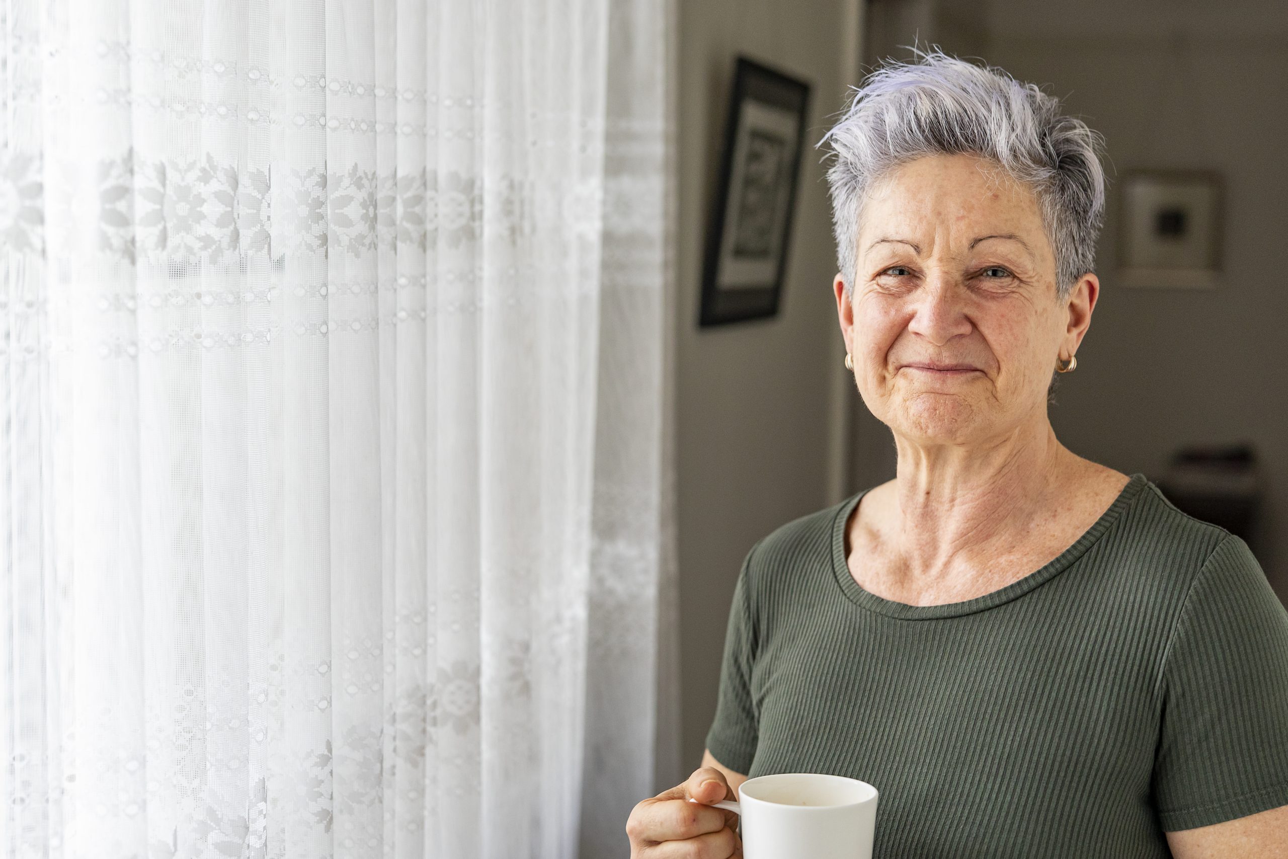Happy older Woman Enjoying A Cup Of Tea At Home